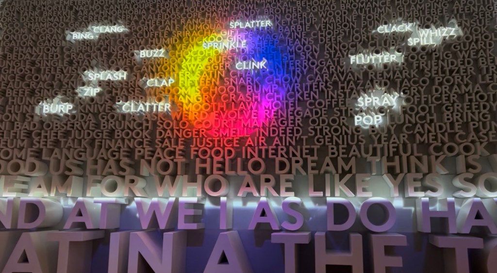 A wall of words, with some highlighted, and a multi-colored circle projected on top.

At Planet Word, the museum dedicated to language, in Washington, DC.